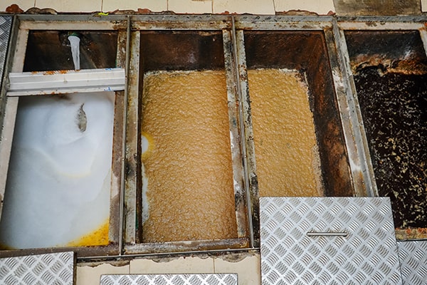 signs that your grease trap needs maintenance include slow drainage, foul odors, and greasy buildup